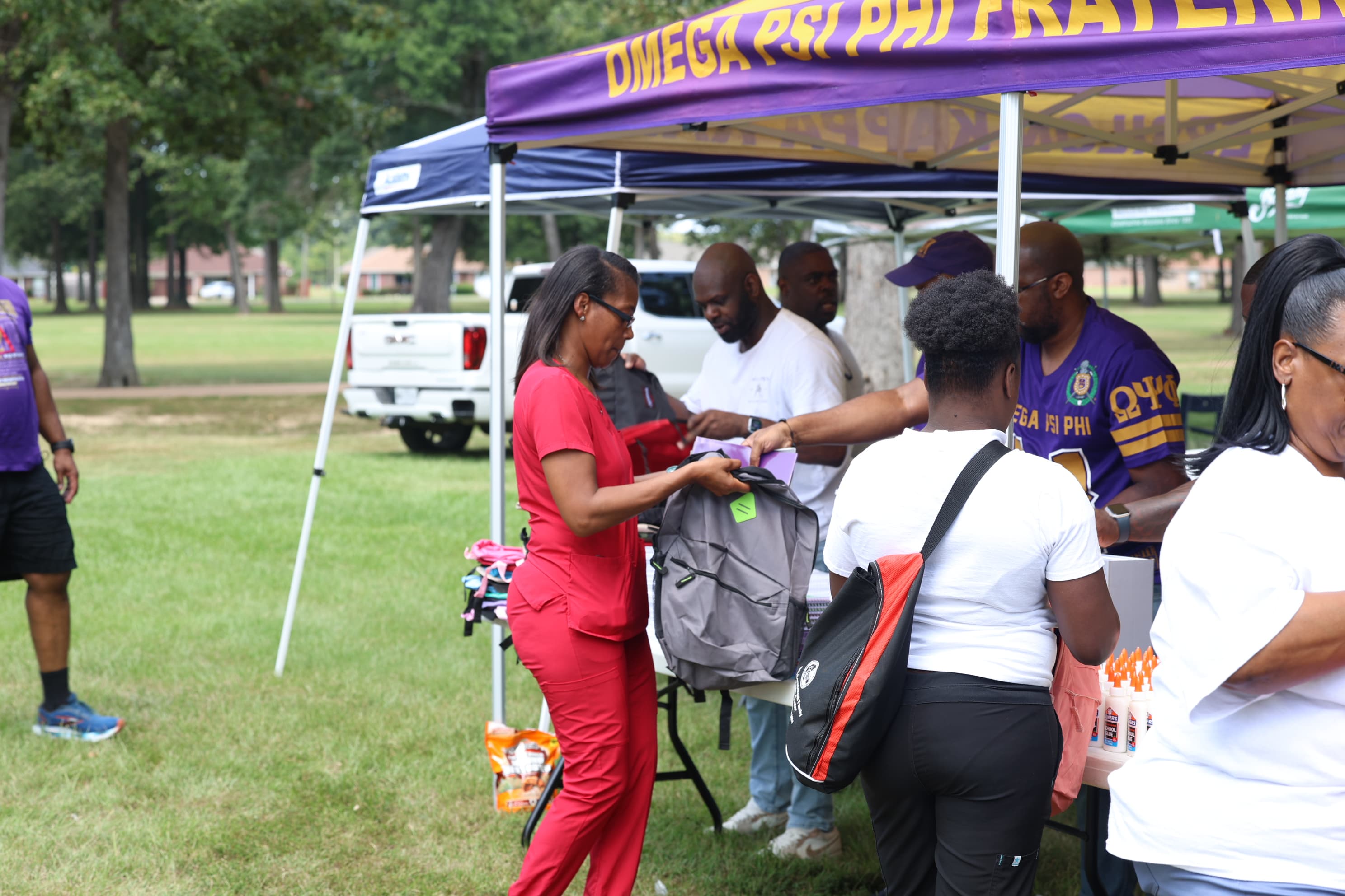 Volunteers handing out backpacks